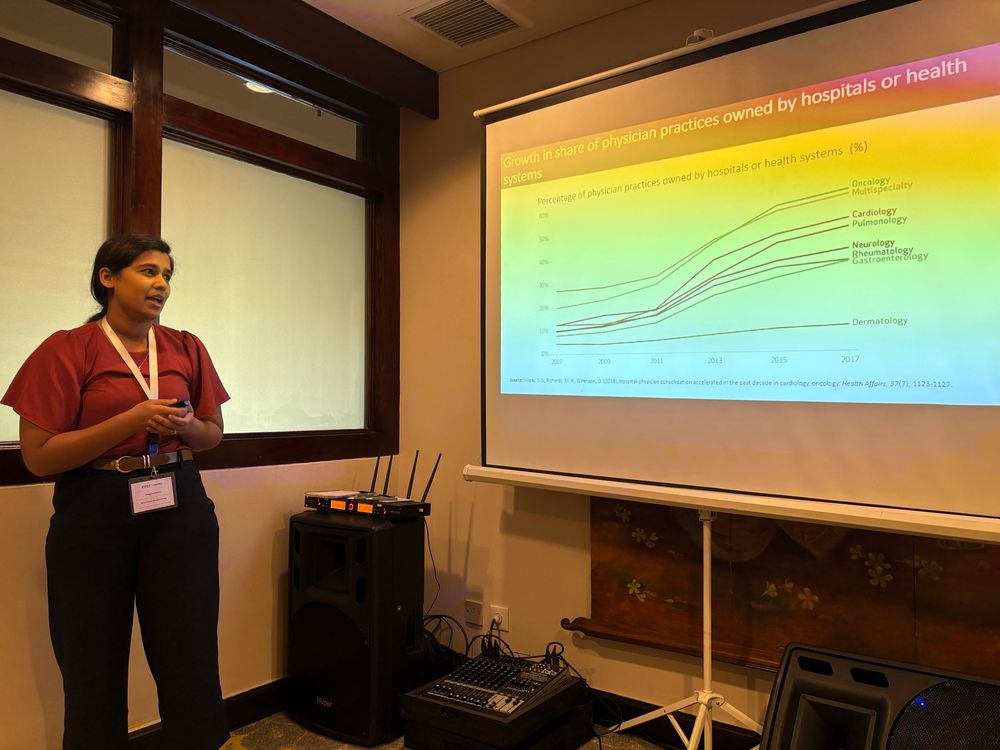 Woman standing in front of graph of upward sloping lines.