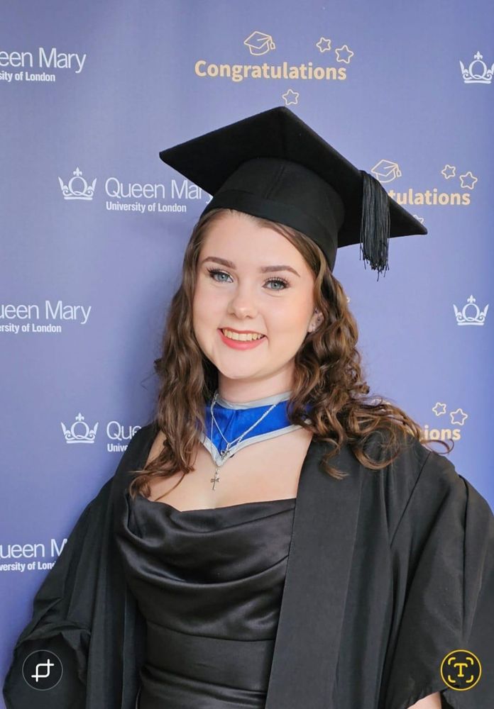 Image description: A photograph of Maddie wearing a black cloak and graduation cap. 