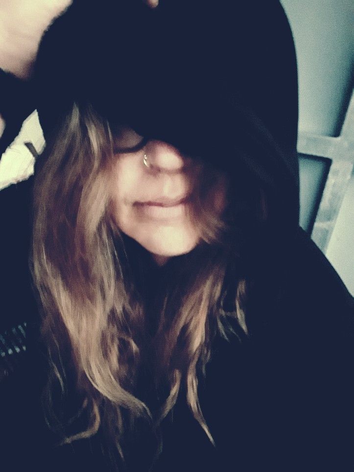 Müde alte Frau, Selfie, das Gesicht größtenteils von einer Kaputze verdeckt, die langen Haare zotteln daraus hervor