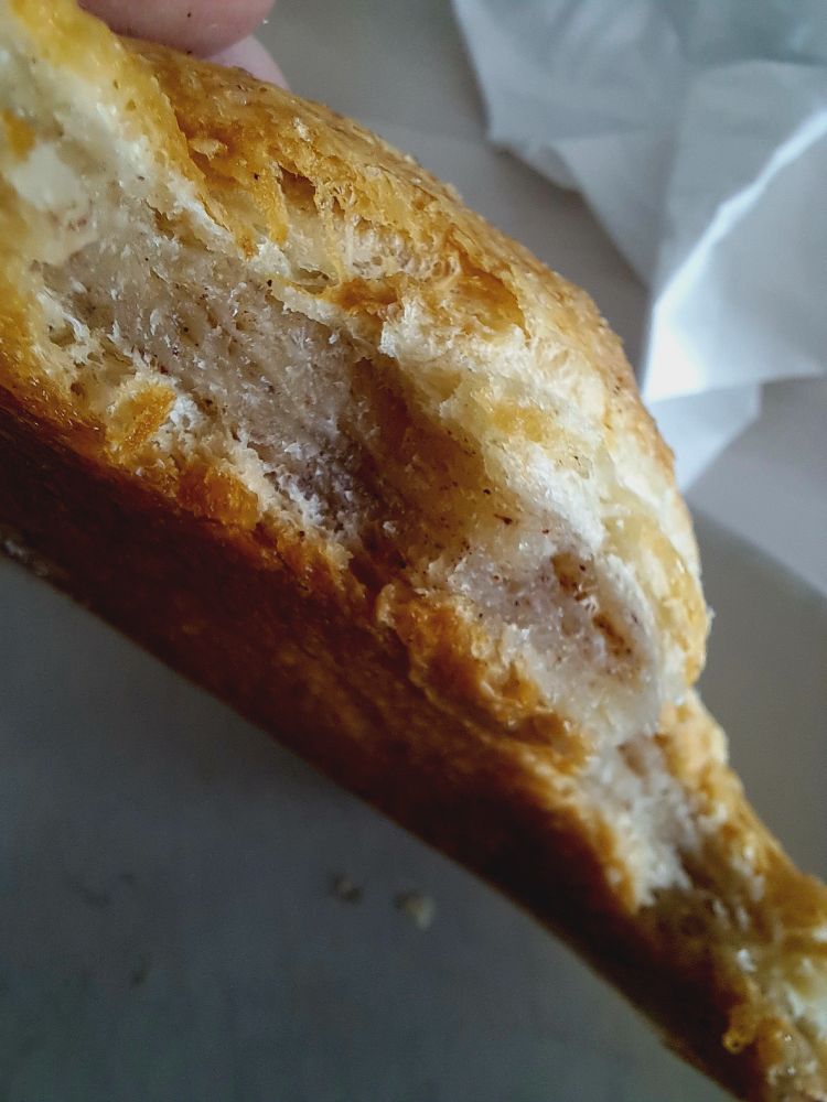 Angebissenes blättriges Gebäck, innen knitschigbuttrigzimtig