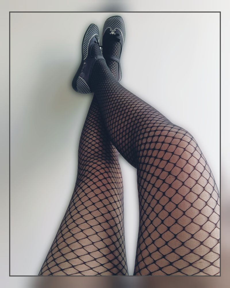 Farbiges Foto das fast nach einem sw Bild aussieht.
Meine Beine lehnen an der Wand, ich trage schwarze Blackadder Strumpfhosen von Snag und dazu meine neuen Chocolaticas Dolores. Die Schuhe sind im Mary Jane Stil mit weißen Polkadots und Totentopf.