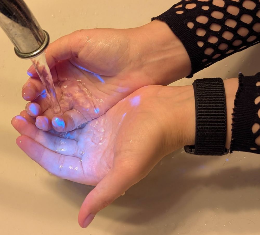 me washing my hands with uv light pointed at them. random blotches of uv reactive ink visible on my hand.
soap and rubbing didn't help. on surfaces isopropyl works, not so well on hands.