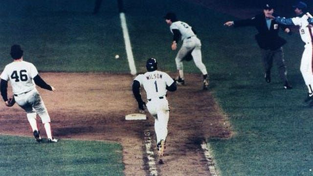 10th inning of game 6, 1986 World Series, Mookie Wilson of the Mets runs to 1st as Bill Buckner tries in vain to retrieve the ball that had just gone through his legs. Umpire and Mets 1B coach Bill Robinson signal that it’s a fair ball.