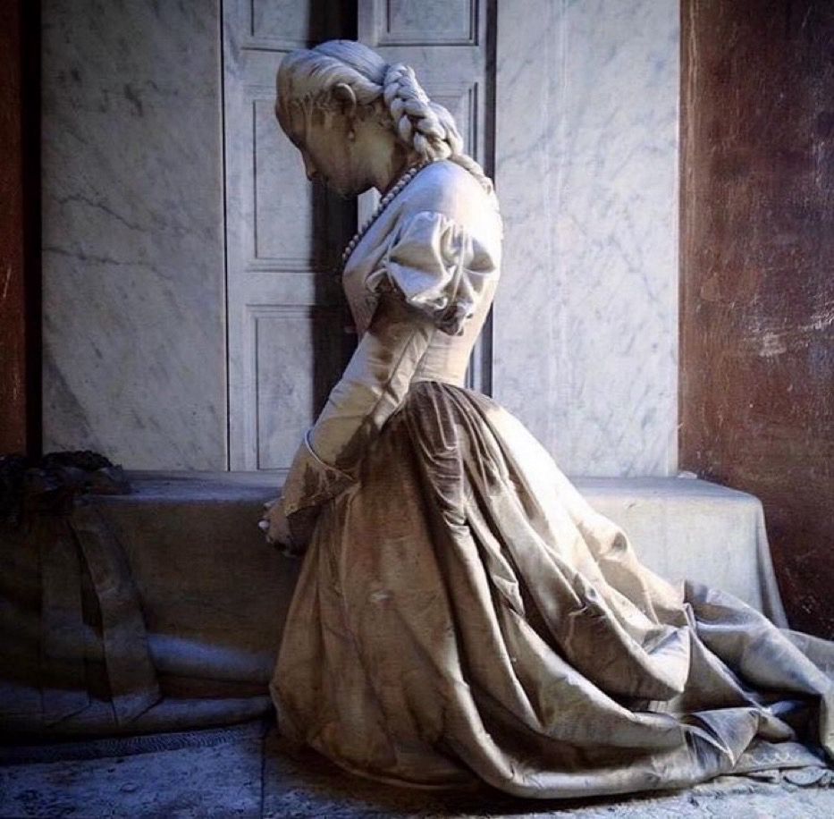 Das Bild einer Frau, die kniet und nach unten schaut