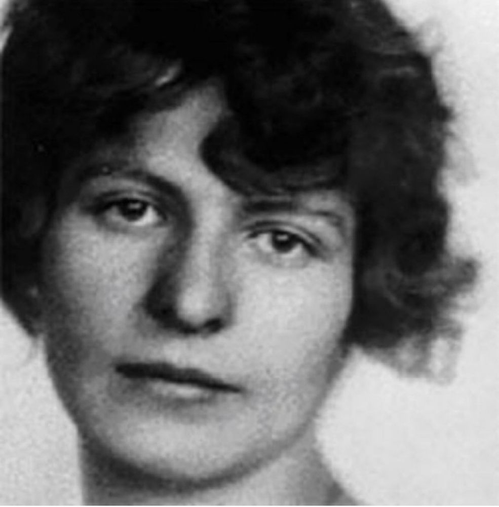 Das Bild einer jungen Frau, mit kurzen, dunklen Haaren, die leicht verträumt in die Kamera schaut