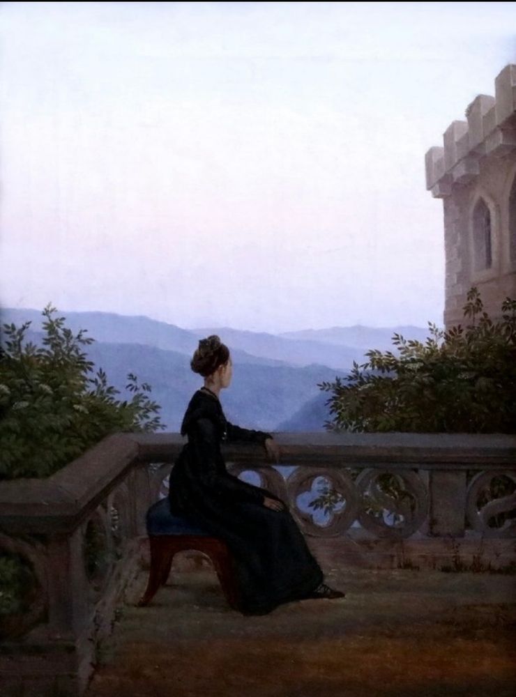 Eine Frau in einem langen Rock sitzt auf einem Balkon, der wohl zu einem Schloss oder zu einer Burg gehört. Das Geländer ist durchbrochen mit einem Muster. Wie schaut in der dahinterliegende Landschaft, blau aussieht. Man sieht nur ihre Silhouette. Weiteres kann man von ihr nicht erkennen?