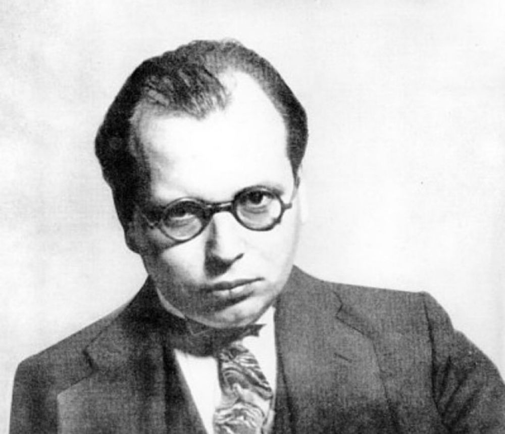 Ein Foto von ihm. Er schaut ernst in die Kamera, ein junger Mann, mit Brille und Anzug.