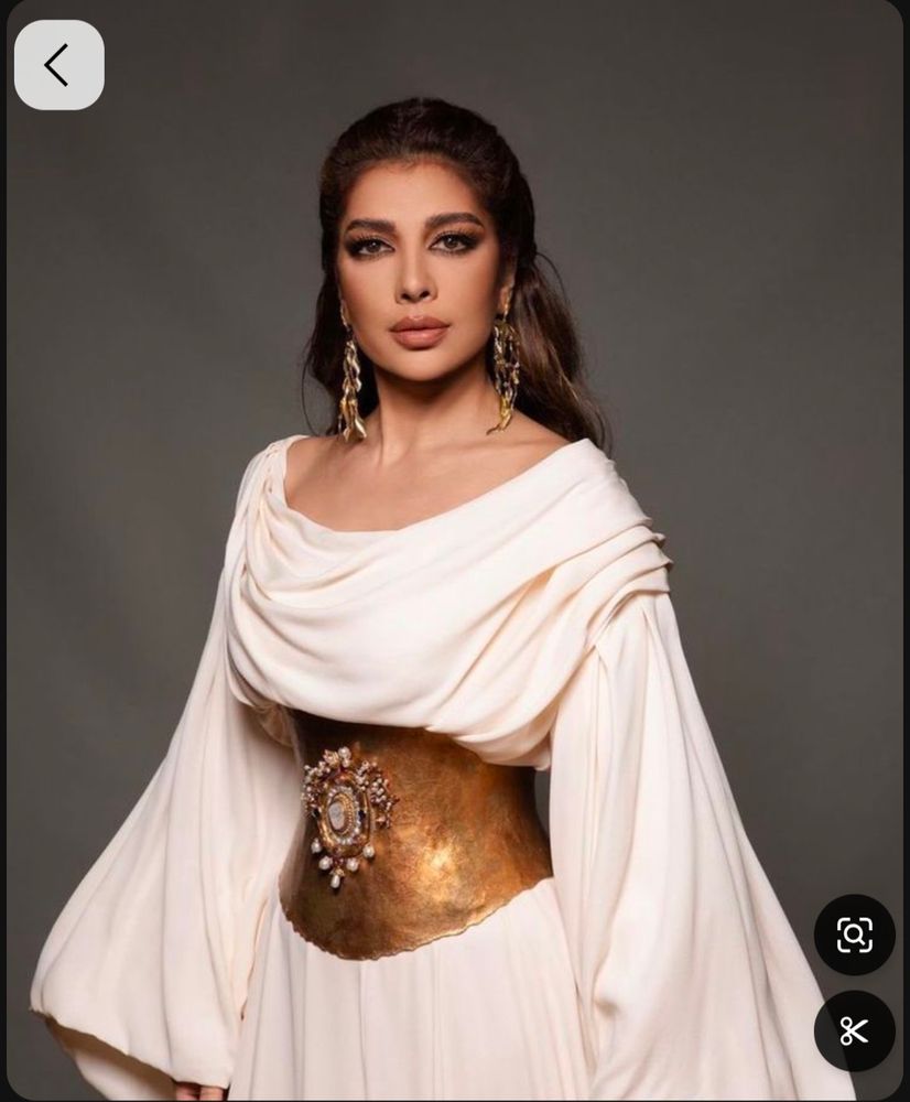 Reference photo of woman in soft white dress and gold metal bodice.