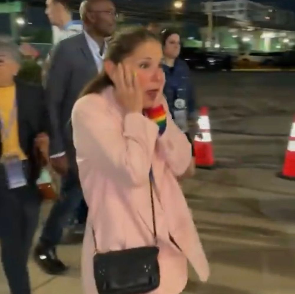 A democrat plugging her ears at the jeers of pro-palestine protesters and walking by