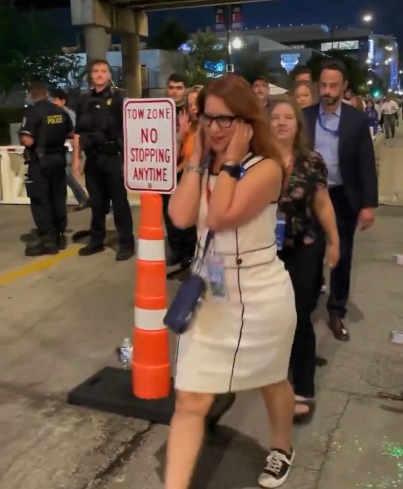 A democrat plugging her ears at the jeers of pro-palestine protesters and scurrying off to a DNC convention