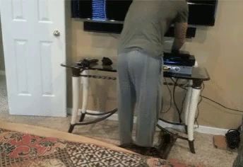 a man is standing in front of a desk with a playstation on it