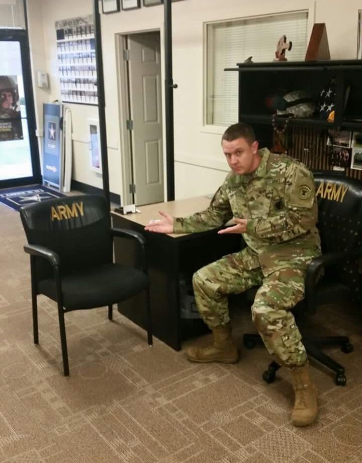 An army recruiter points at an empty chair