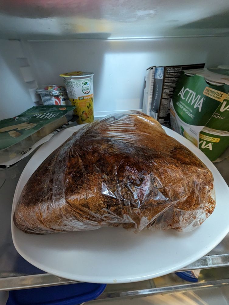 Makrofoto von 1,6kg Schopf mit Coffee Rub in Cellophane eingepackt in einem Kühlschrank