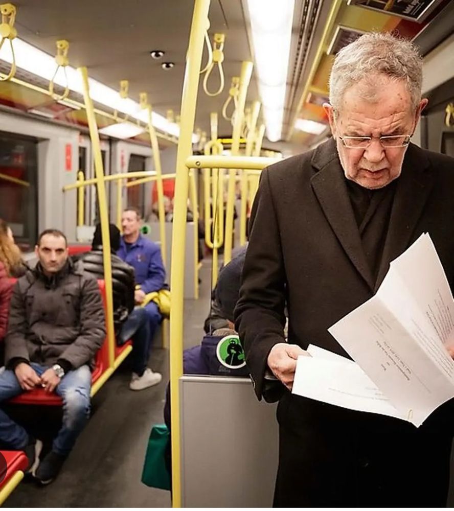 Image showing the Austrian President Alexander Van der Bellen riding the subway and reading a newspaper.