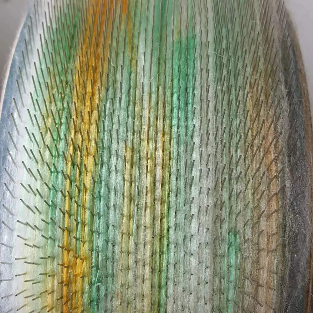 The Shetland fibre and mulberry silk sitting in the drumcarder teeth.