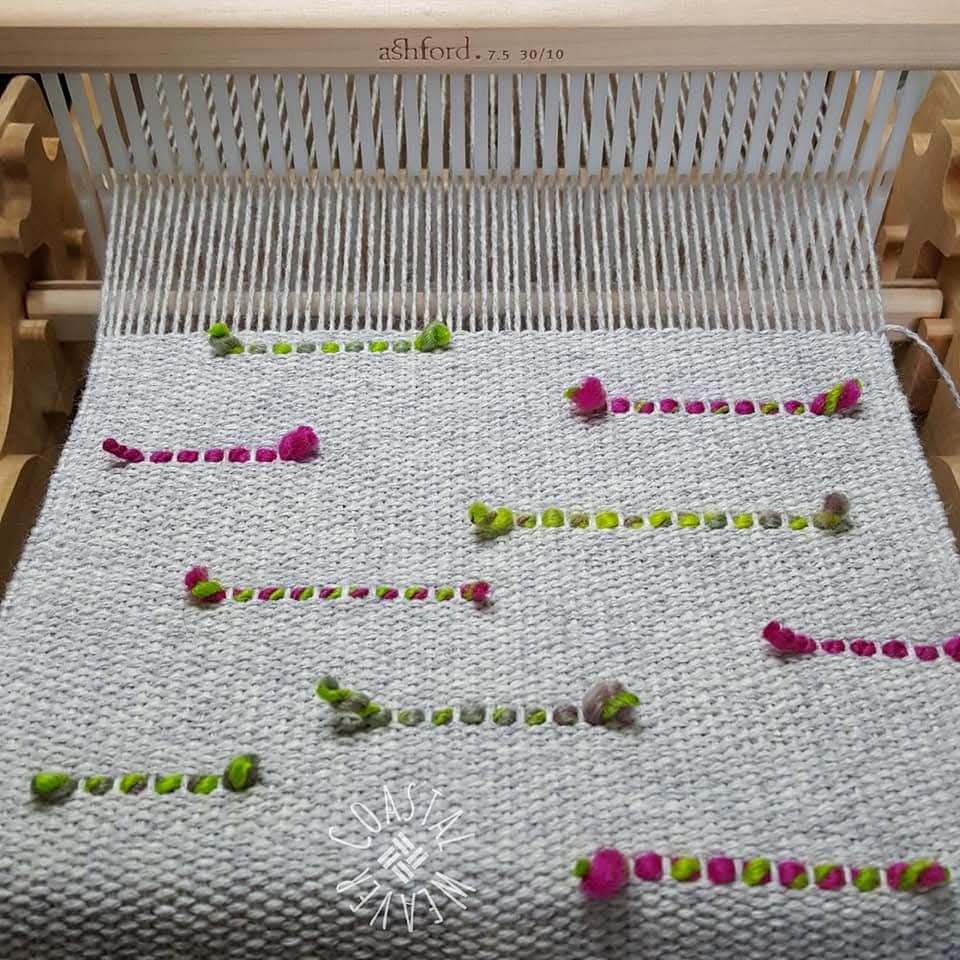 Commercial 100% wool yarn with hand spun merino inserts sitting on a rigid heddle loom.