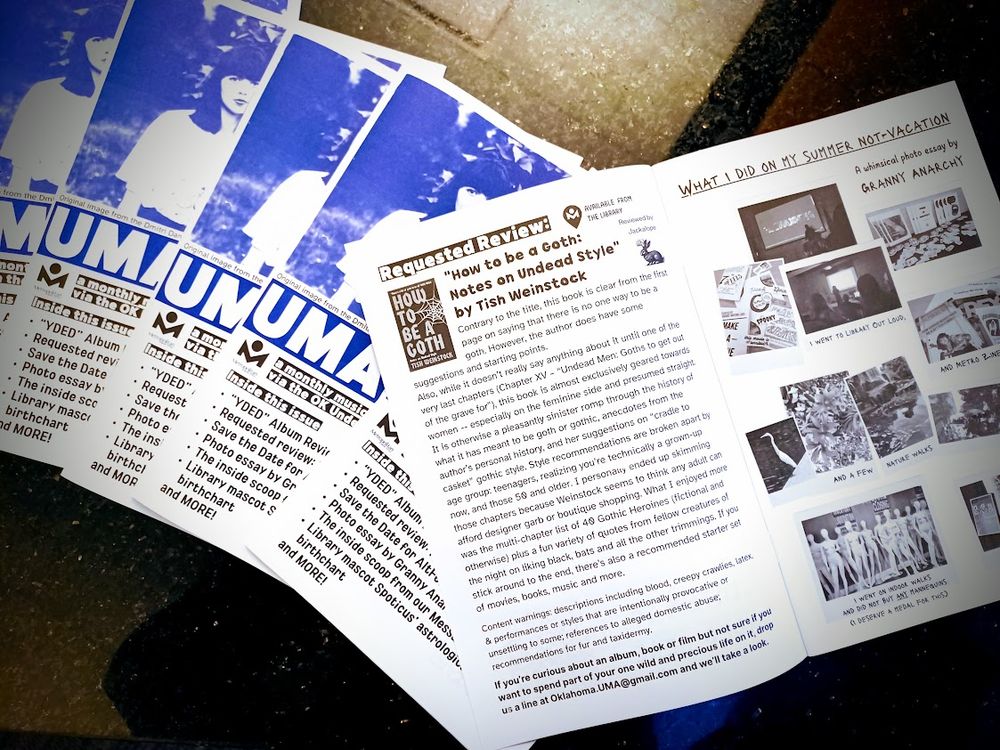 A small stack of August issue UMAmi alternative music & lifestyle Oklahoma Underground Music Archive zines with one open to display content featuring a photo essay by Granny Anarchy