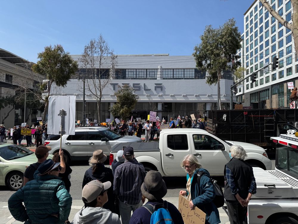 Large crowd in front of the San Francisco Tesla dealership protesting Elon Musk and Donald Trump