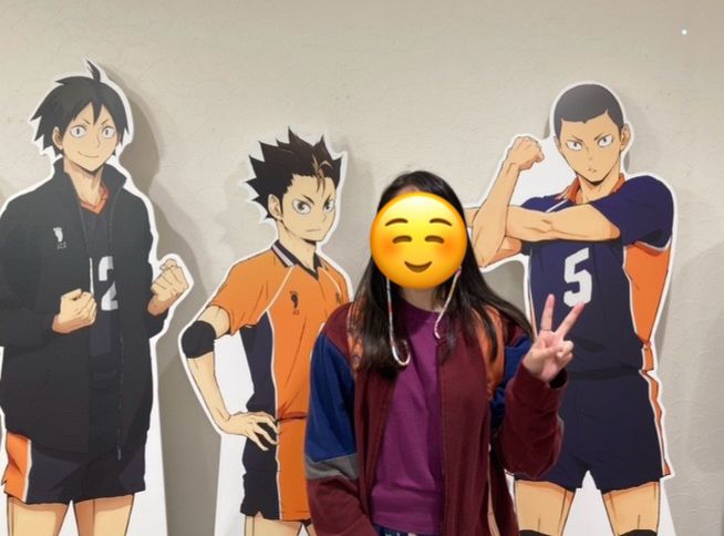 cardboard standees of yamaguchi, nishinoya, and tanaka with a person holding up a peace sign