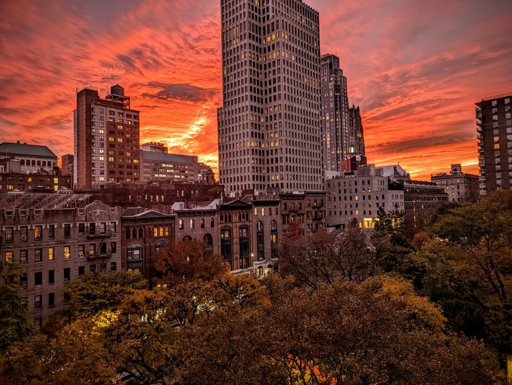 Epic sunset in Manhattan with autumn colored trees and buildings 