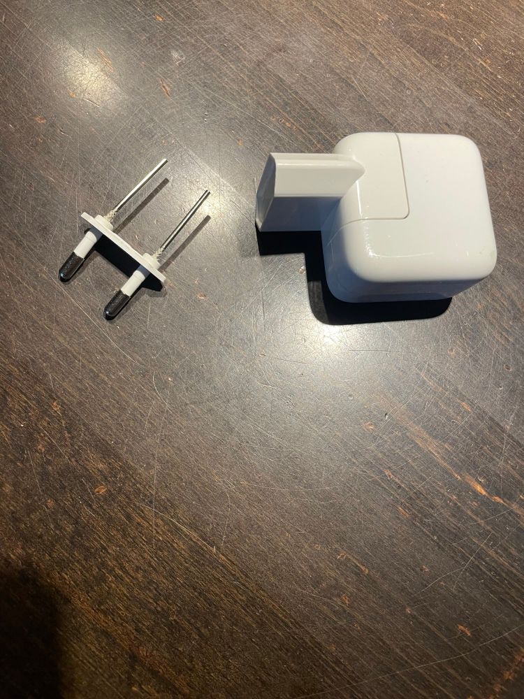 Defektes Apple-Netzteil: Metallstifte haben sich von Kunststoff gelöst.