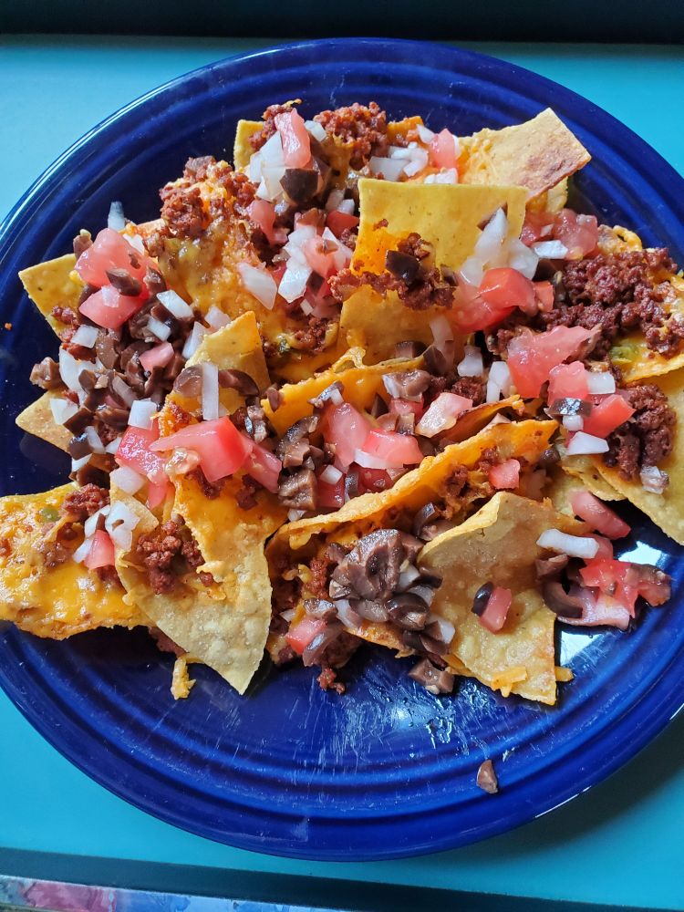 A blue plate full of nachos.