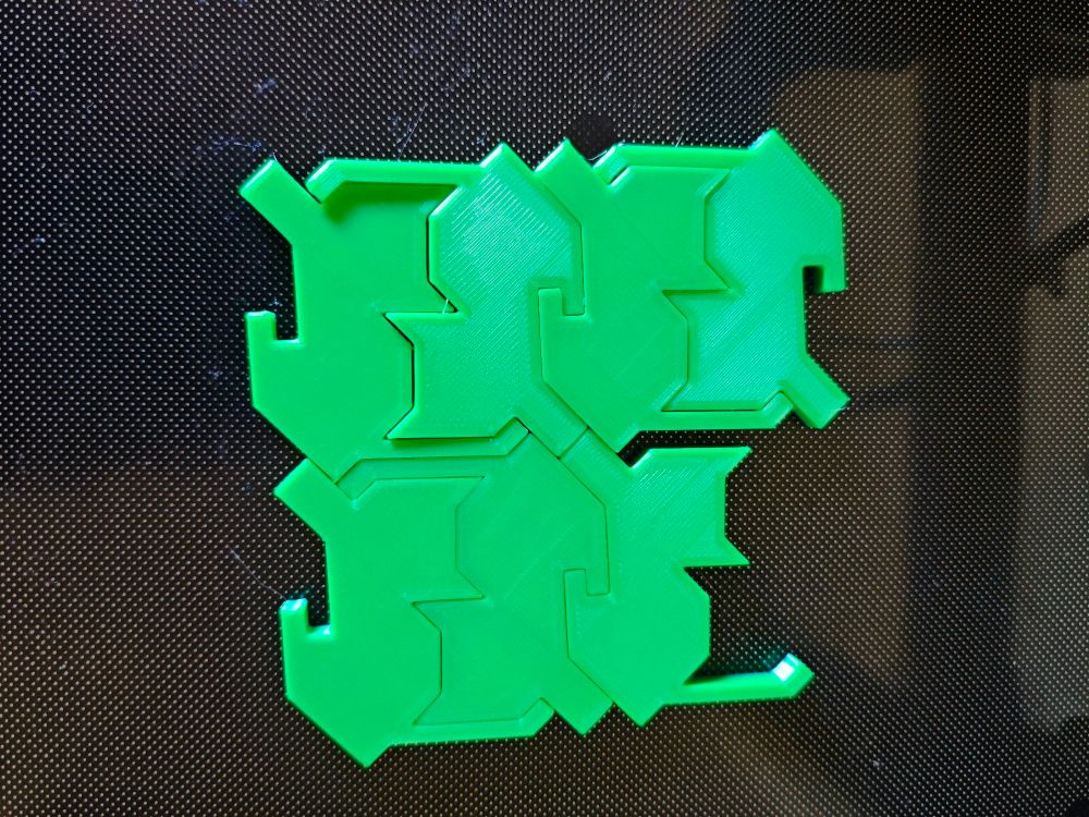 The cat paver design everyone was loving a day or so ago, but 3d printed in green filament