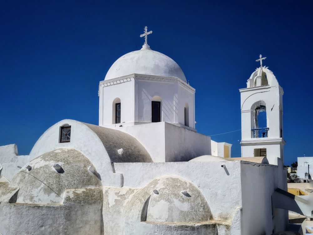 Une petite église dans le village de Mégalochori à Santorin, avec son Dôme blanc qui se détache sur le ciel bleu. 