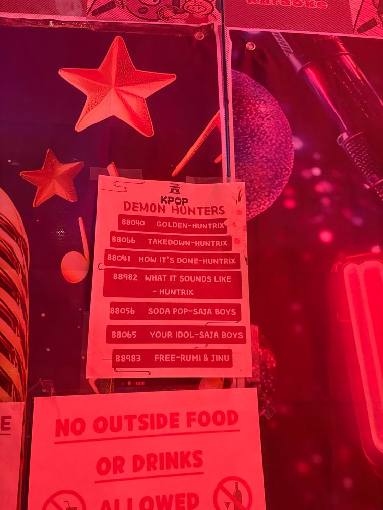 a red-lit photo of a flyer with kpop demon hunters karaoke codes