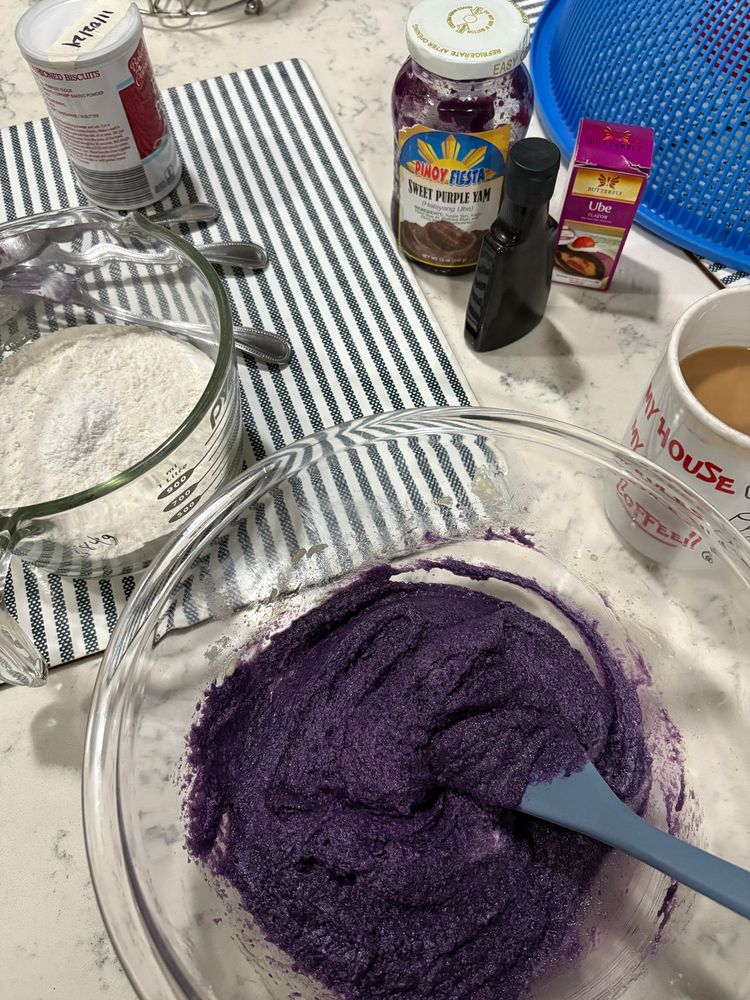 baking setup of a large measuring cup with flour and a large bowl of purple batter