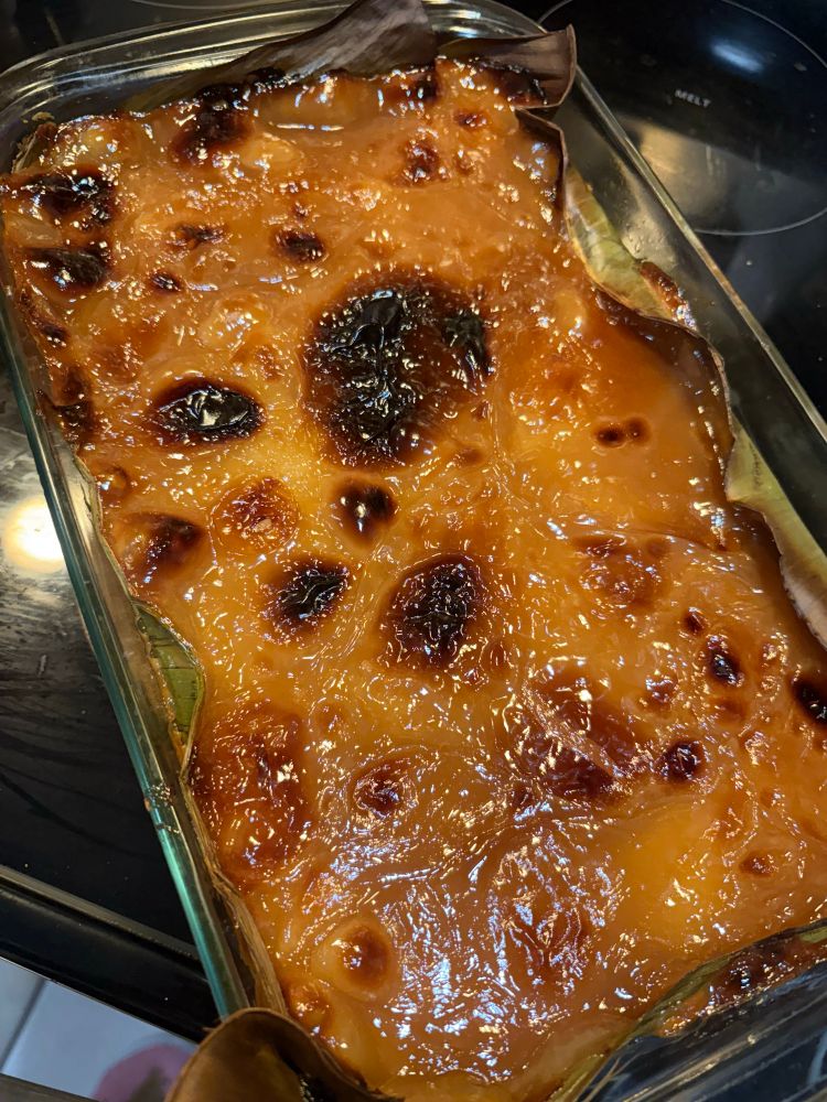 a glass dish lined with banana leaves, sticky rice with a blistered caramel top
