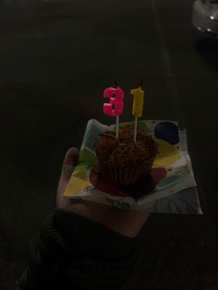 a toasted coconut cupcake with 3 and 1 candles
