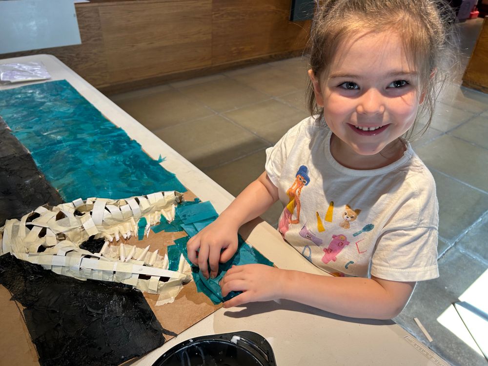 A young girl helping with the making of the skull. 
