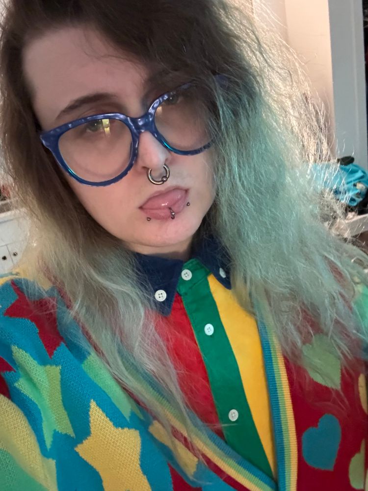 selfie of sophia hjkl wearing a colorful button up shirt under a colorful cardigan 