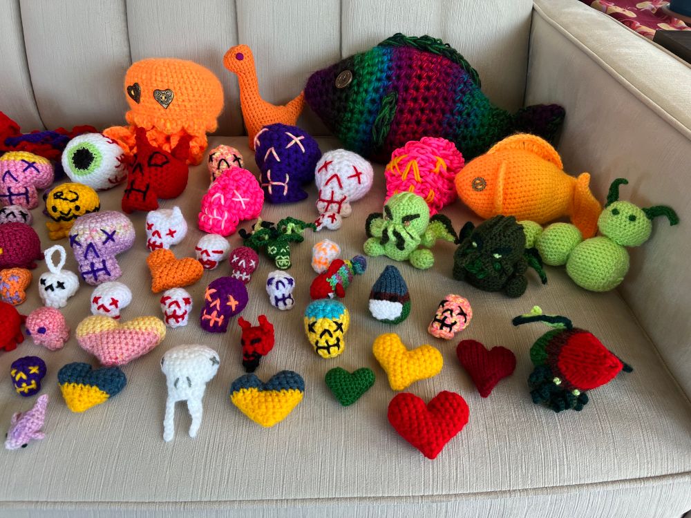 A multicolored menagerie of crocheter skulls, fish, hearts, cthulhus, eyeballs, caterpillars and mice of various sizes