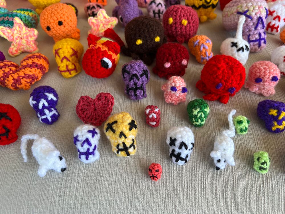 A multicolored menagerie of crocheter skulls, fish, hearts, cthulhus, eyeballs, caterpillars and mice of various sizes