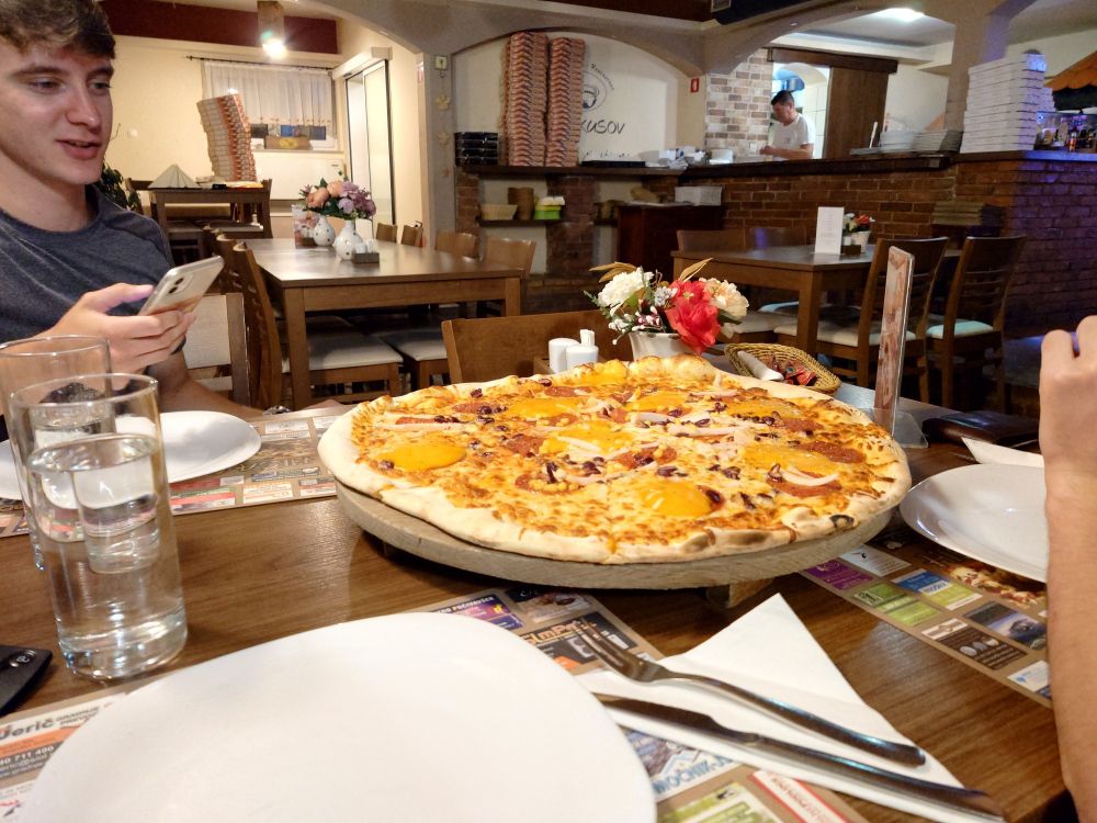 A large mexican pizza in the middle of a table.