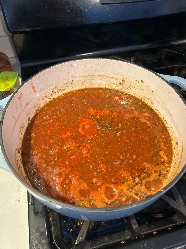 A bubbling pot of tomato-based meat sauce 