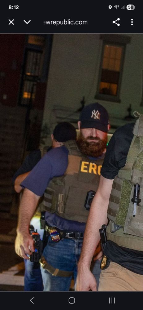 Man wearing tactical gear and a NY Yankees hat.