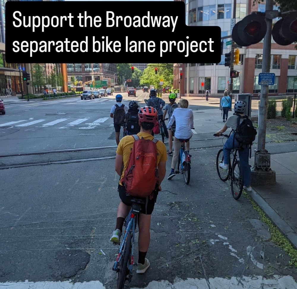 A photo of at least 7 cyclists stopped at a red light on Broadway in Cambridge, their backs to the camera. Text overlaid at the top left corner reads, "Support the Broadway separated bike lane project."