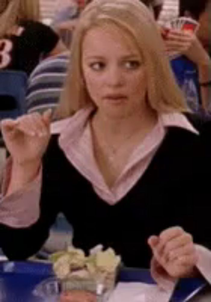 a woman is sitting at a table with a plate of food in front of her .