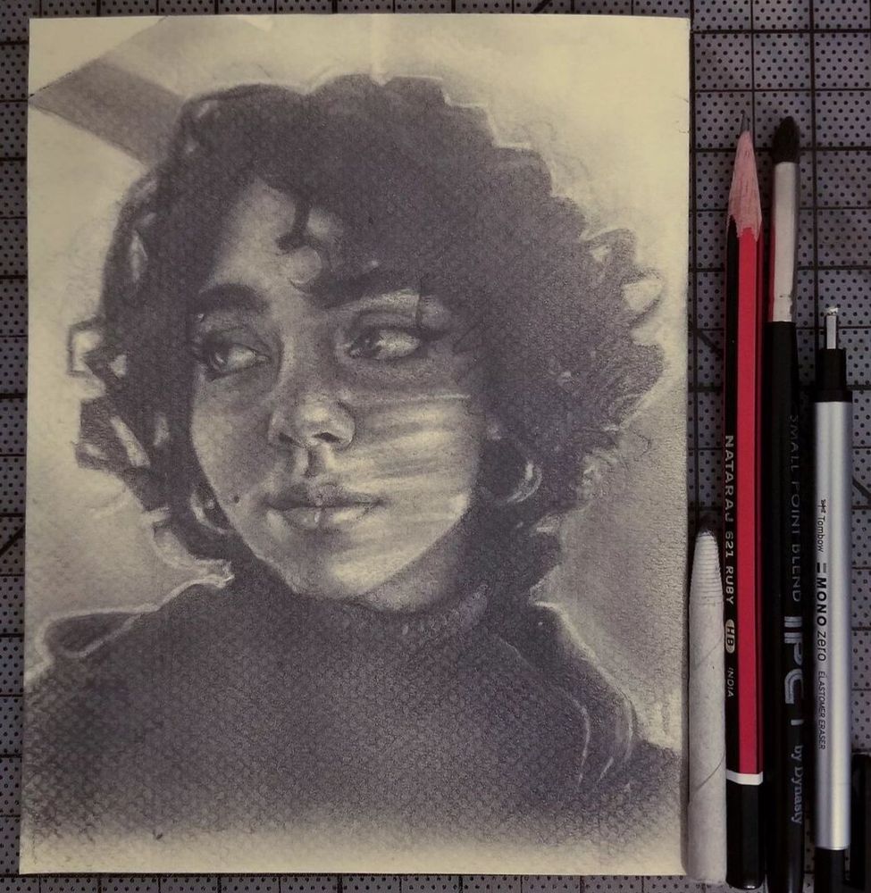 A graphite drawing on textured, cream-colored paper of a young woman with curly hair and hoop earrings looking to her left, while the striped shadows of window blinds reflect on the right side of her face. The drawing tools used to make it are aligned next to it