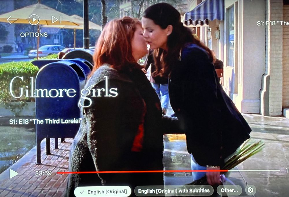 An episode of Gilmore Girls paused at a moment where it looks like Lorelai and Sookie are about to kiss