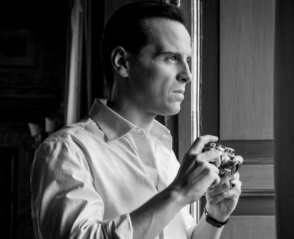 Cena em preto e branco do Ripley fotografando de uma janela.