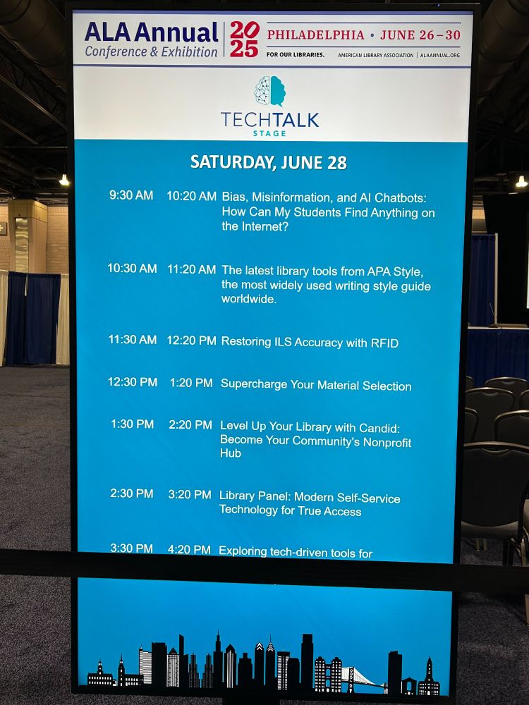 A display at the Philadelphia Convention Center shows the ALA Annual Convention's Tech Talk Stage schedule for Saturday, June 28:
9:30 AM–10:20 AM Bias, Misinformation, and AI Chatbots: How Can My Students Find Anything on the Internet?
10:30 AM–11:20 AM The latest library tools from APA Style, the most widely used writing style guide worldwide.
11:30 AM–12:20 PM Restoring ILS Accuracy with RFID
12:30 PM–1:20 PM Supercharge Your Material Selection
1:30 PM–2:20 PM Level UP Your Library with Candid: Become Your Community's Nonprofit Hub
2:30 PM–3:20 PM Library Panel: Modern Self-Service Technology for True Access
3:30 PM–4:20 PM Exploring tech-driving tools for 