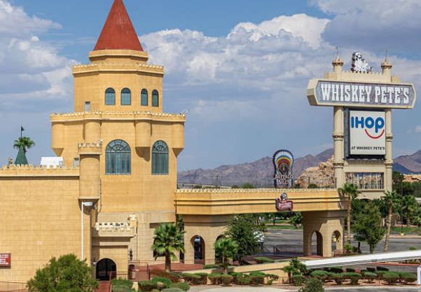 A derelict "Whiskey Pete's' sign, above an iHop sign, attached to an abandoned hotel in the mostly abandoned mini-Sin City of Primm, Nevada.
