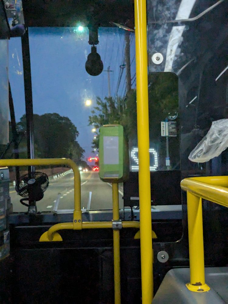 A bus fare machine being covered over with green tape and paper