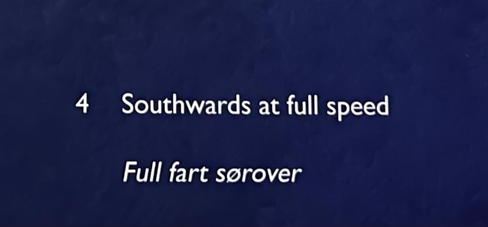 Cropped pic of the description of an art piece in a museum in Norway. It reads In English "Southwards at full speed" and the Norwegian translation reads "Full fart sørover".