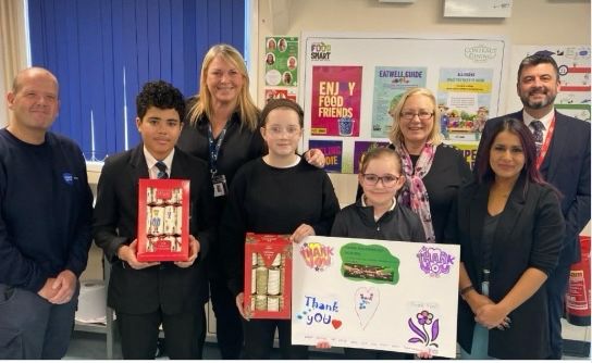 Staff and pupils from Rivermead School being presented with Christmas crackers by Councillors Tracy Coombs and Dan MacDonald and Naushabah Khan MP