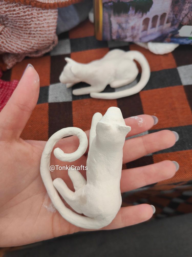 Overhead view of two sculpted paper clay jaguars before they have been painted.